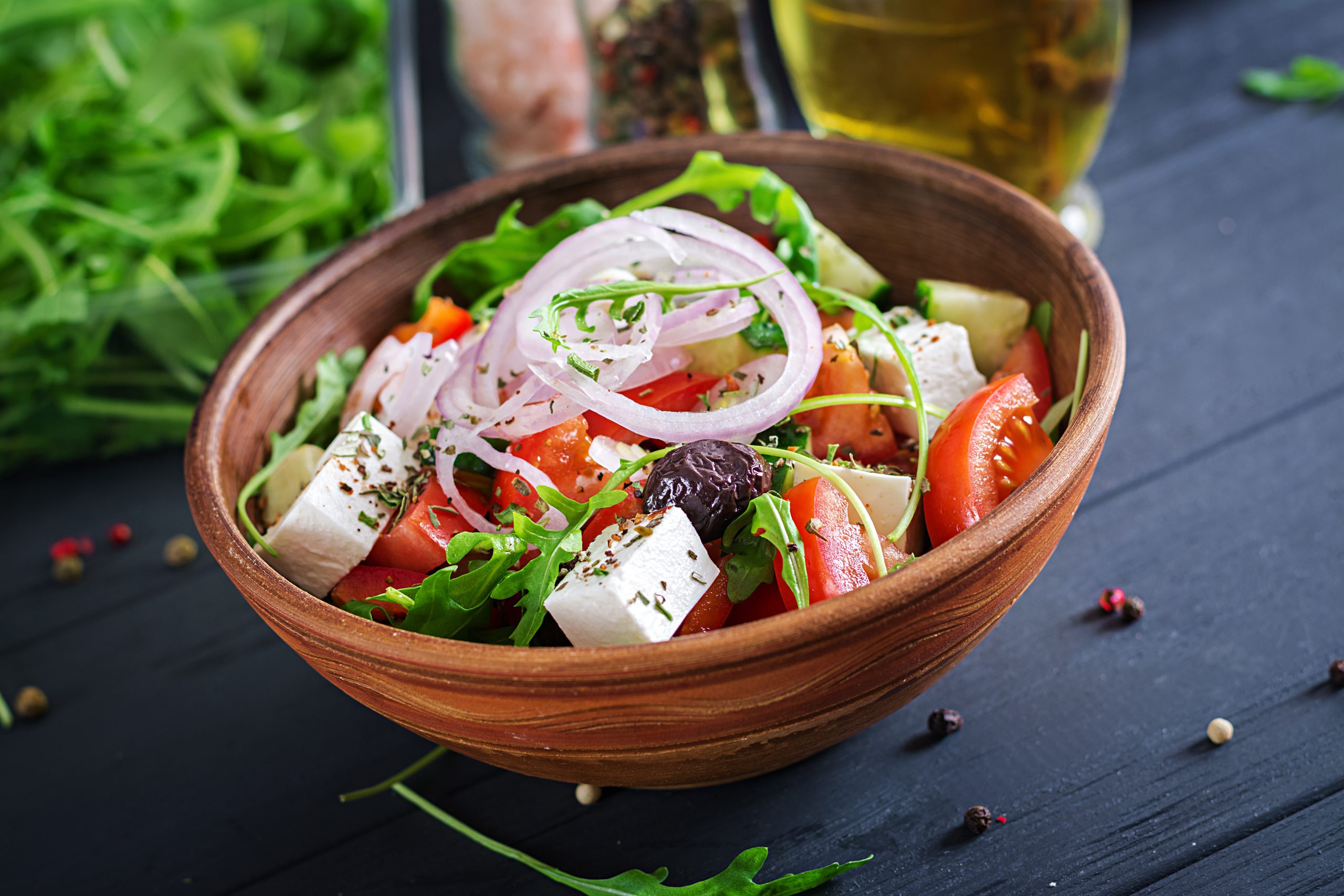 Greek salad with fresh tomato, cucumber, red onion, basil, feta cheese, black olives and Italian herbs